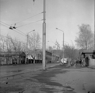 Воскресенская церковь в 1970-е годы: улица, вдали — колокольня